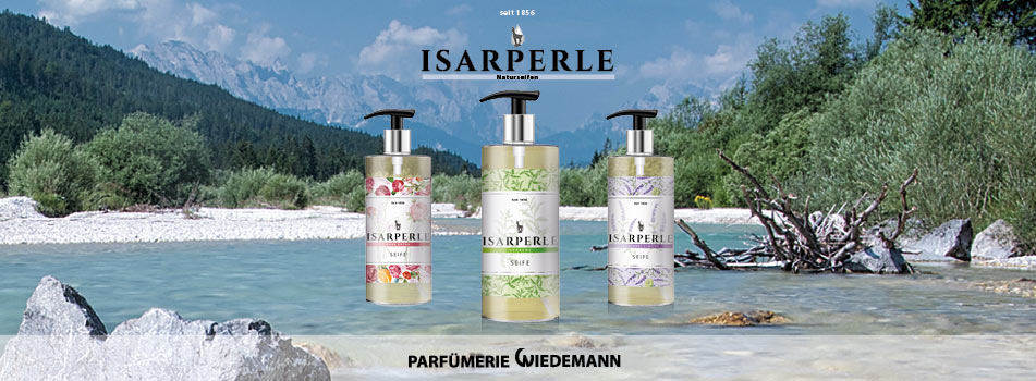 Drei Flaschen der Pflegemarke Isarperle mit Pumpspender stehen in einer alpinen Flusslandschaft mit klarem Wasser, Felsen und Bergen im Hintergrund. Darüber das Logo „Isarperle Naturseifen“ und unten der Schriftzug „Parfümerie Wiedemann“.