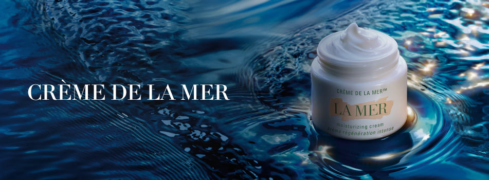 Werbebild für ‚Crème de la Mer‘. Ein geöffneter Tiegel der Feuchtigkeitscreme steht auf einer glänzenden, dunkelblauen Wasseroberfläche. Links im Bild steht der Schriftzug: ‚Crème de la Mer‘ in eleganter weißer Schrift.