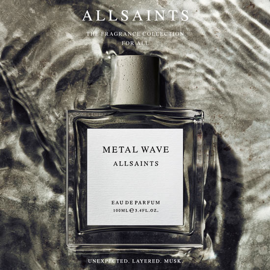 Parfumflakon „Metal Wave“ von ALLSAINTS liegt auf einer silbrig schimmernden, welligen Oberfläche. Darüber steht „ALLSAINTS – The Fragrance Collection for All“, darunter der Schriftzug „Unexpected. Layered. Musk.“