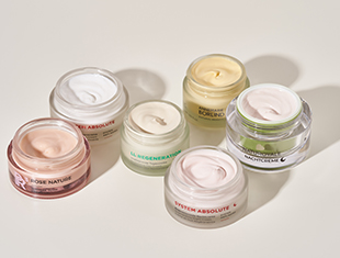 Fünf Glastiegel mit verschiedenen Gesichtscremes in zartem Rosa, Grün, Weiß und Beige – Gesichtspflegeprodukte von ANNEMARIE BÖRLIND.