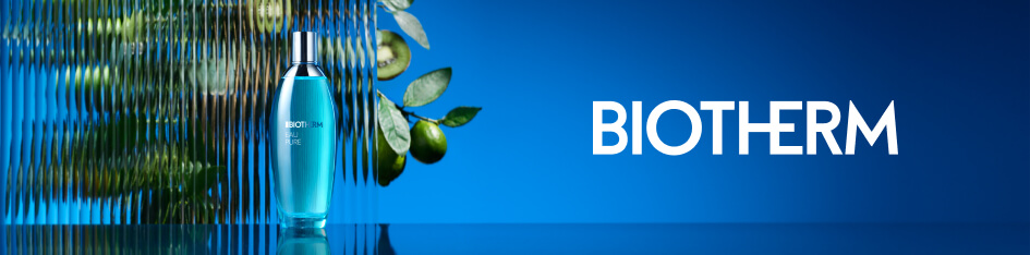 Werbung für Biotherm Pure. Eine türkisfarbene Parfümflasche steht auf reflektierendem Untergrund vor einer geriffelten Glasfläche mit grünen Früchten und Blättern im Hintergrund. Rechts befindet sich das Biotherm-Logo auf blauem Farbverlauf.