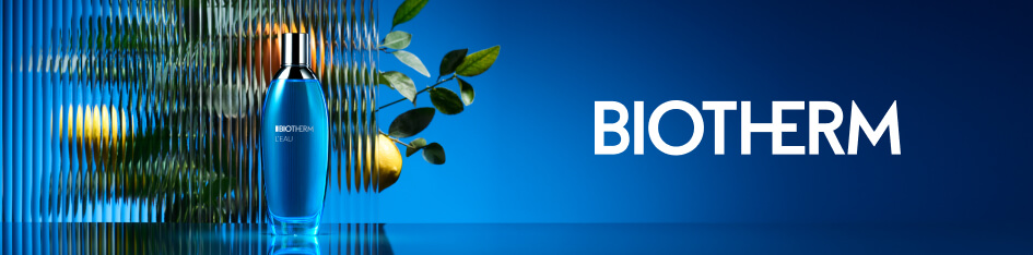 Werbung für Biotherm L’Eau. Eine blaue Parfümflasche steht auf spiegelndem Untergrund vor einer gewellten Glasfläche mit Zitrusfrüchten und Blättern im Hintergrund. Rechts im Bild steht der Markenname 'Biotherm' auf dunkelblauem Hintergrund.