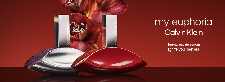 Werbeanzeige für 'my euphoria' von Calvin Klein. Zwei elegante Parfümflakons in Lippenform stehen im Vordergrund – einer in glänzendem Silber, der andere in tiefem Rot. Dahinter befinden sich dunkelrote Orchideenblüten. Rechts im Bild steht der weiße Schriftzug 'my euphoria Calvin Klein', darunter 'the new eau de parfum' und 'ignite your senses' auf rotem Hintergrund.