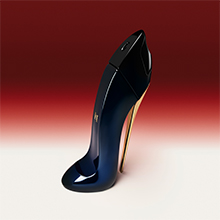 Parfümflakon in Form eines schwarzen High Heels mit goldenem Absatz, auf einem Farbverlauf-Hintergrund von Weiß zu Rot. Beschriftung darunter: 'Good Girl'.