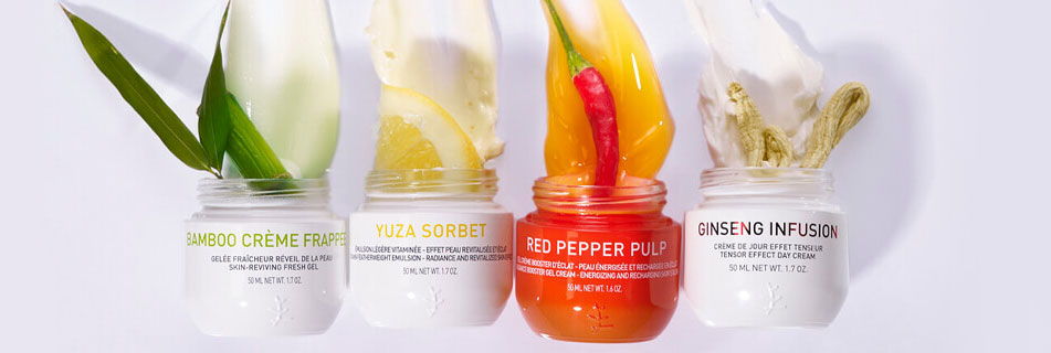 Vier geöffnete Gesichtspflege-Tiegel von Erborian: Bamboo Crème Frappée mit Bambusblatt, Yuza Sorbet mit Zitronenscheibe, Red Pepper Pulp mit roter Chili und Paprika, Ginseng Infusion mit Ginsengwurzel – jeweils mit sichtbarer Creme-Textur.