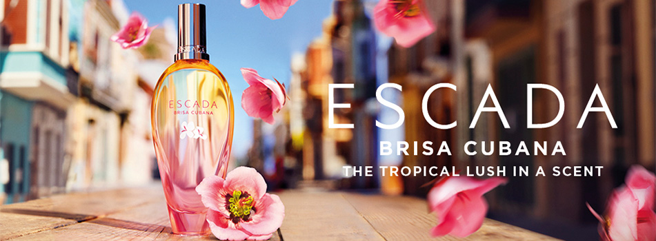 ESCADA Brisa Cubana Parfumflakon vor einer farbenfrohen Straßenszene mit fliegenden rosa Blüten, daneben der Schriftzug: 'ESCADA Brisa Cubana – The tropical lush in a scent'.