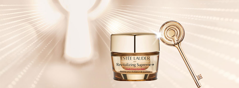 Werbemotiv für Estée Lauder Revitalizing Supreme+ Youth Power Eye Balm vor einem hellgoldenen Hintergrund in Form eines leuchtenden Schlüssellochs, daneben ein goldener Schlüssel mit Lichtreflexion.