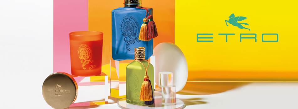 Bunte Duft- und Pflegeprodukte von ETRO, darunter ein orangefarbenes Glas mit Paisley-Motiv, ein blaues und ein grünes Parfumflakon mit Quaste sowie eine goldene Dose. Im Hintergrund ein leuchtendes Farbspiel in Pink, Orange und Gelb mit ETRO-Logo in Blau.