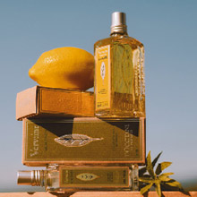 L'OCCITANE Zitronen-Duftöl mit frischen Zitronen und goldener Verpackung in natürlichem Licht.