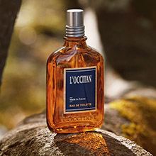 L'OCCITANE Herrenparfum in brauner Glasflasche mit natürlicher Stein-Kulisse.