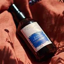 L'OCCITANE Lavendel-Spray auf weichem Stoff mit warmem Licht.