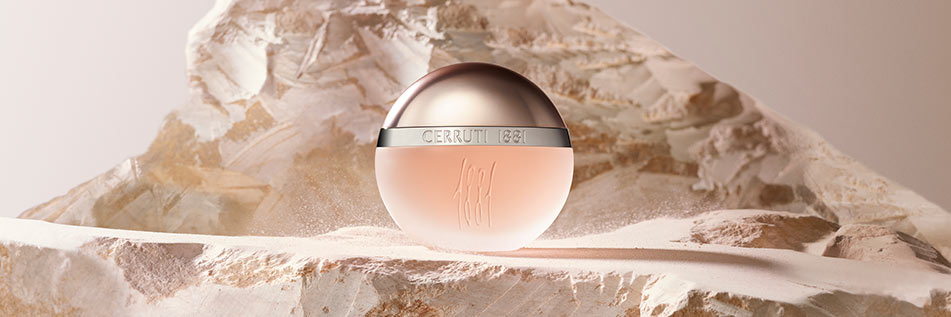 Rosa-runder Parfumflakon von Cerruti 1881 mit silberner Kappe, kunstvoll in einer hellen, steinigen Landschaft inszeniert. Der Hintergrund und die Oberfläche wirken wie aus Marmor oder Sandstein, wodurch der Flakon besonders edel hervorgehoben wird.